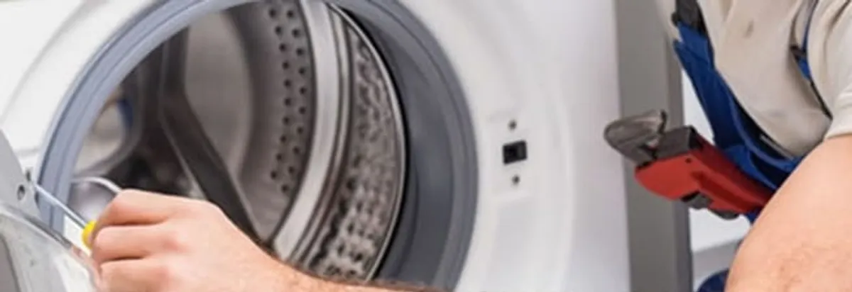Appliance technician repairing a clothes dryer drum and internal parts in Cape Coral, FL