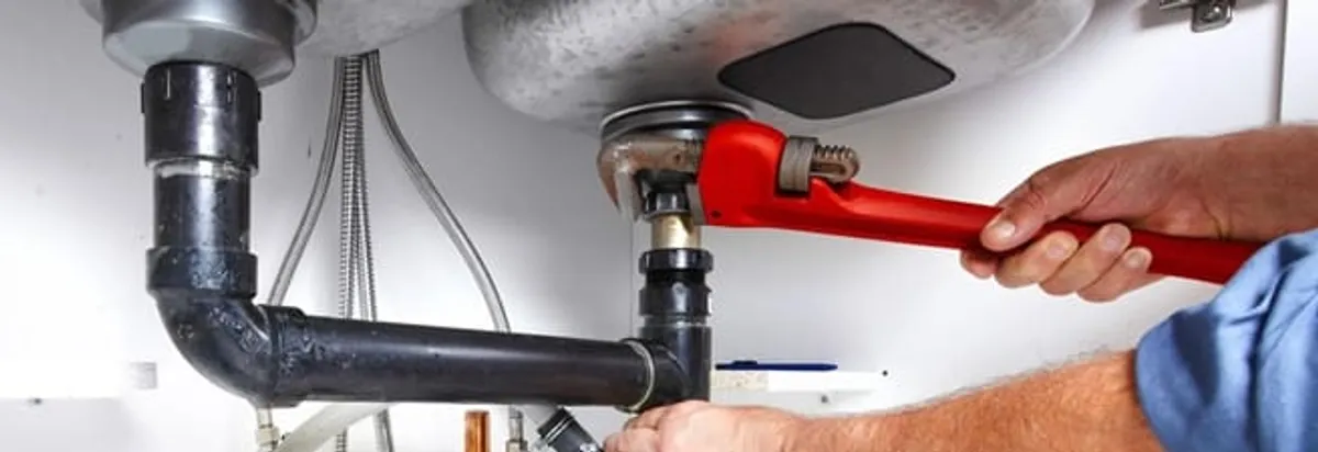 Garbage disposal repair technician tightening the sink drain and disposal connection in Cape Coral, FL