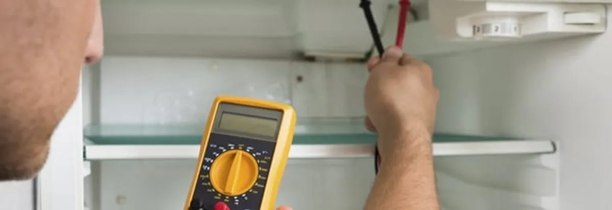 Refrigerator repair technician testing electrical components with a multimeter in Cape Coral, FL