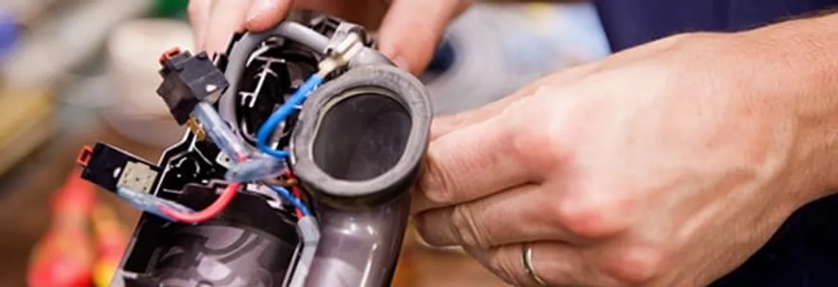 Vacuum repair technician reconnecting wiring and components in Cape Coral, FL